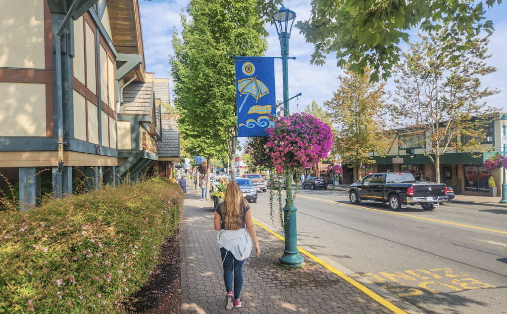 A woman walks in downtown Qualicum Beach, learning about qualicum beach business news.